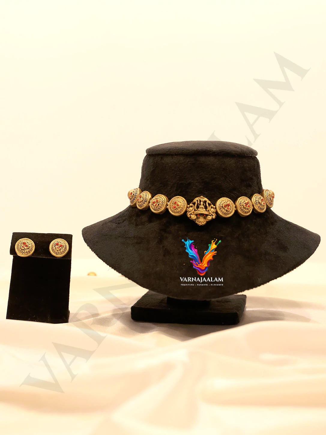 Handcrafted matte gold terracotta choker necklace featuring a Goddess Lakshmi center pendant, carved circular coin beads with red accents, and matching stud earrings