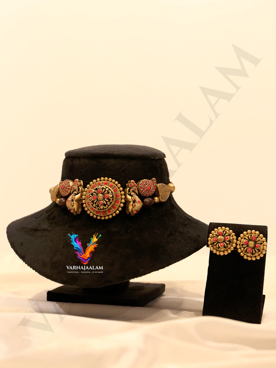 Handcrafted terracotta choker with red floral medallion, gold peacocks, and matching stud earrings