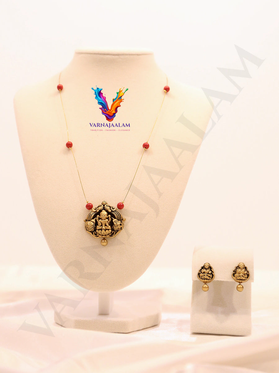 Terracotta Lakshmi motif pendant on invisible wire chain with red bead accents and matching stud earrings