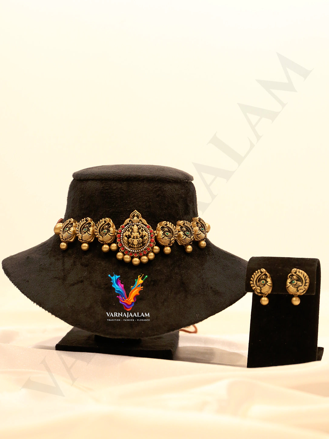 Handcrafted terracotta choker featuring a central Lakshmi medallion, flanked by antique gold peacocks and matching peacock drop earrings