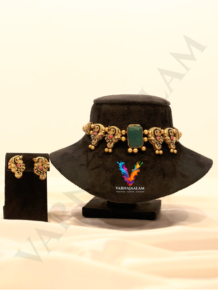 Handcrafted terracotta choker with rectangular green centerpiece, antique gold peacocks, and matching peacock stud earrings