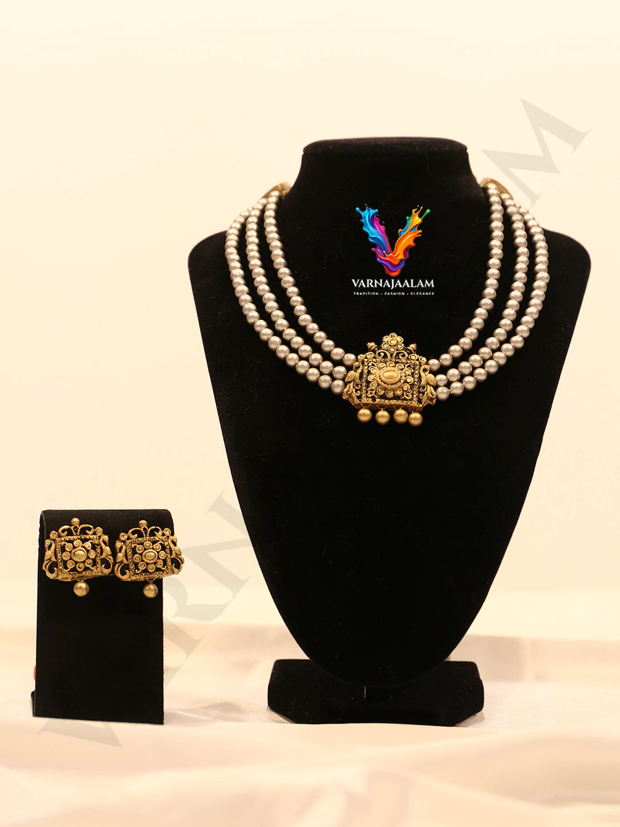 Three-strand grey terracotta pearl necklace featuring an ornate square terracotta pendant and matching stud earrings