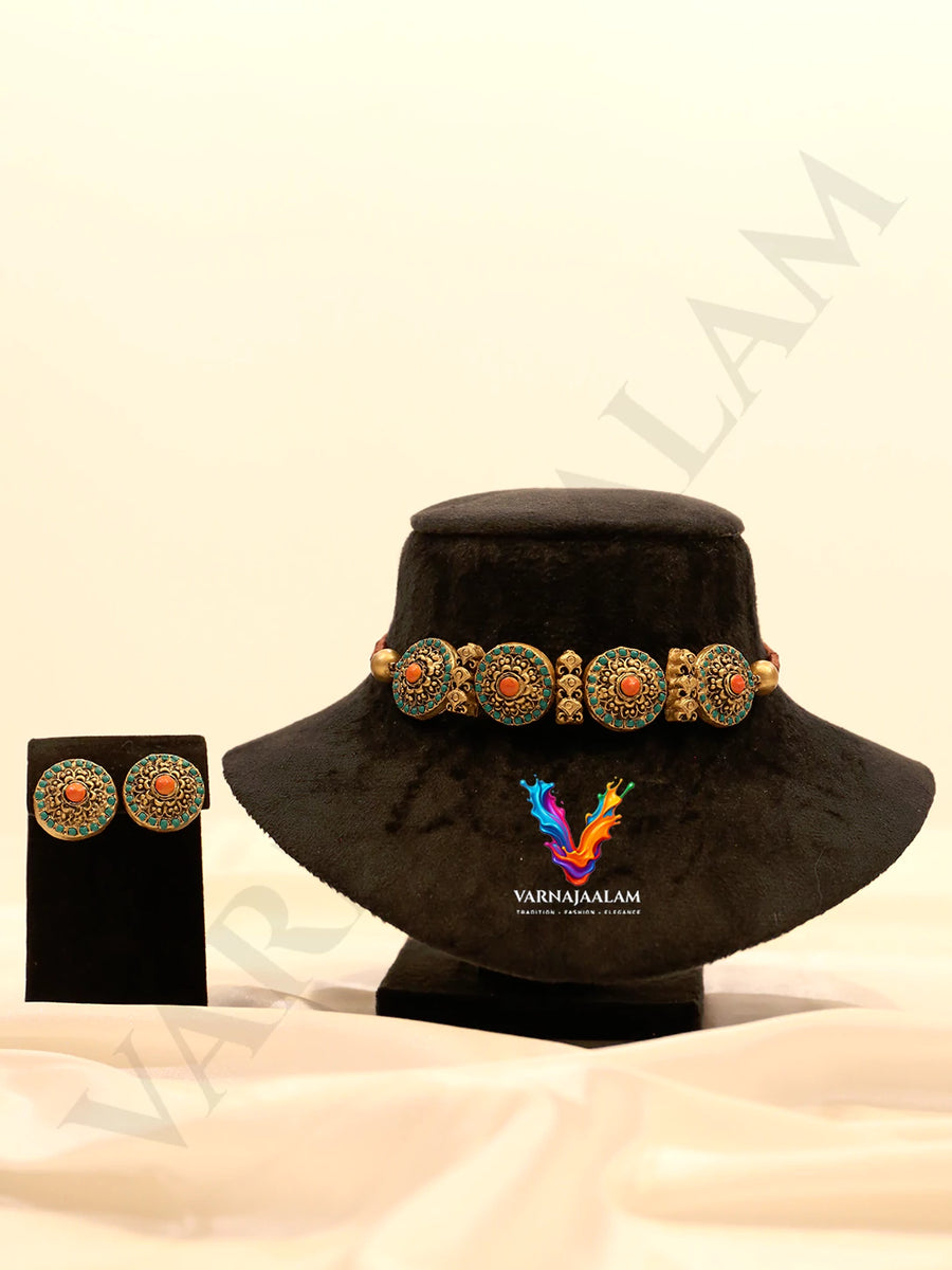 Terracotta choker with orange and green chakra wheel medallions, antique gold motifs, and matching round stud earrings