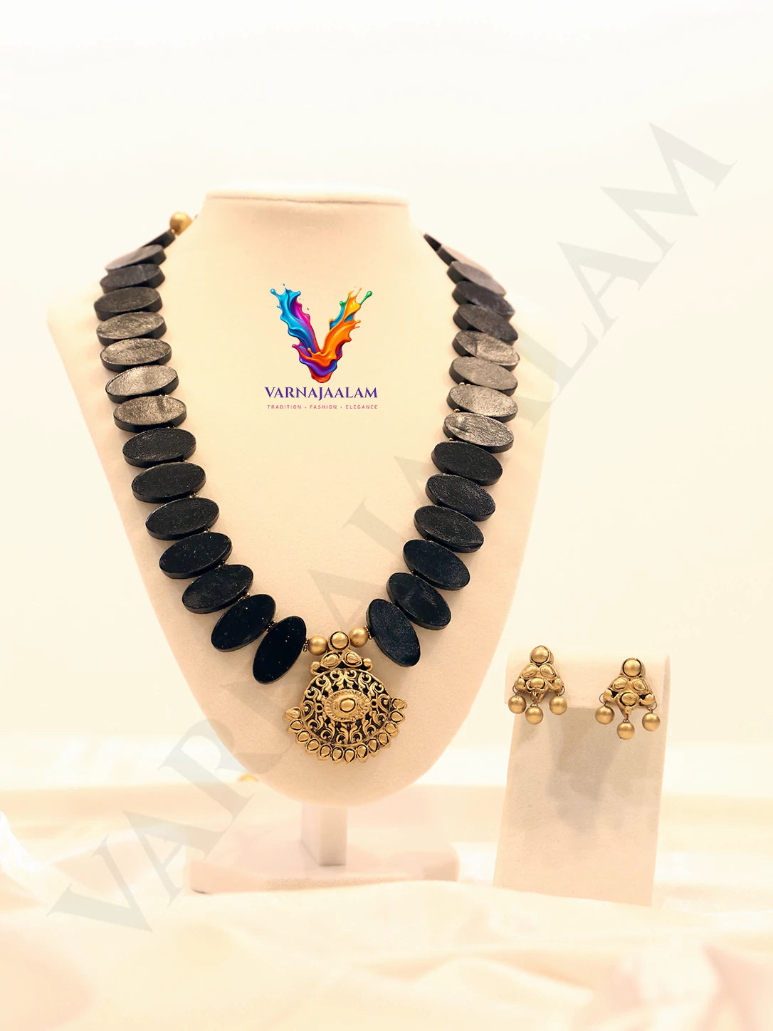 Terracotta mala necklace with flat black oval beads, antique gold central pendant, and matching drop earrings