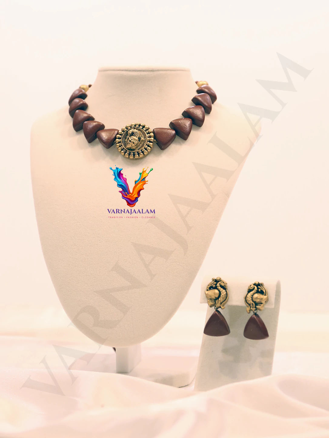 Terracotta choker with brown triangular beads, a central antique gold peacock medallion, and matching peacock drop earrings