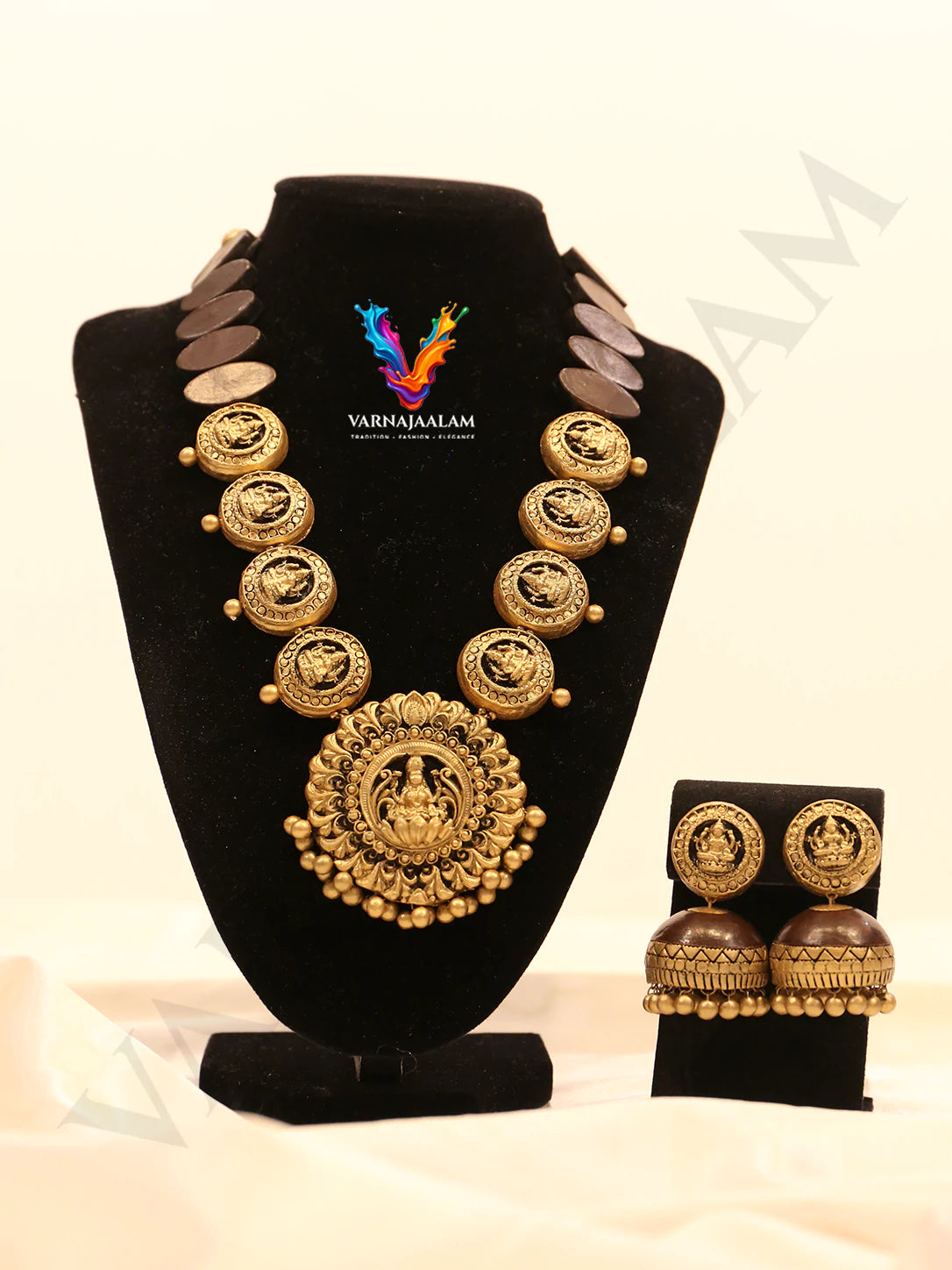 Handcrafted terracotta long mala with round Lakshmi coins, dark wooden-look oval beads, central medallion, and matching jhumka earrings