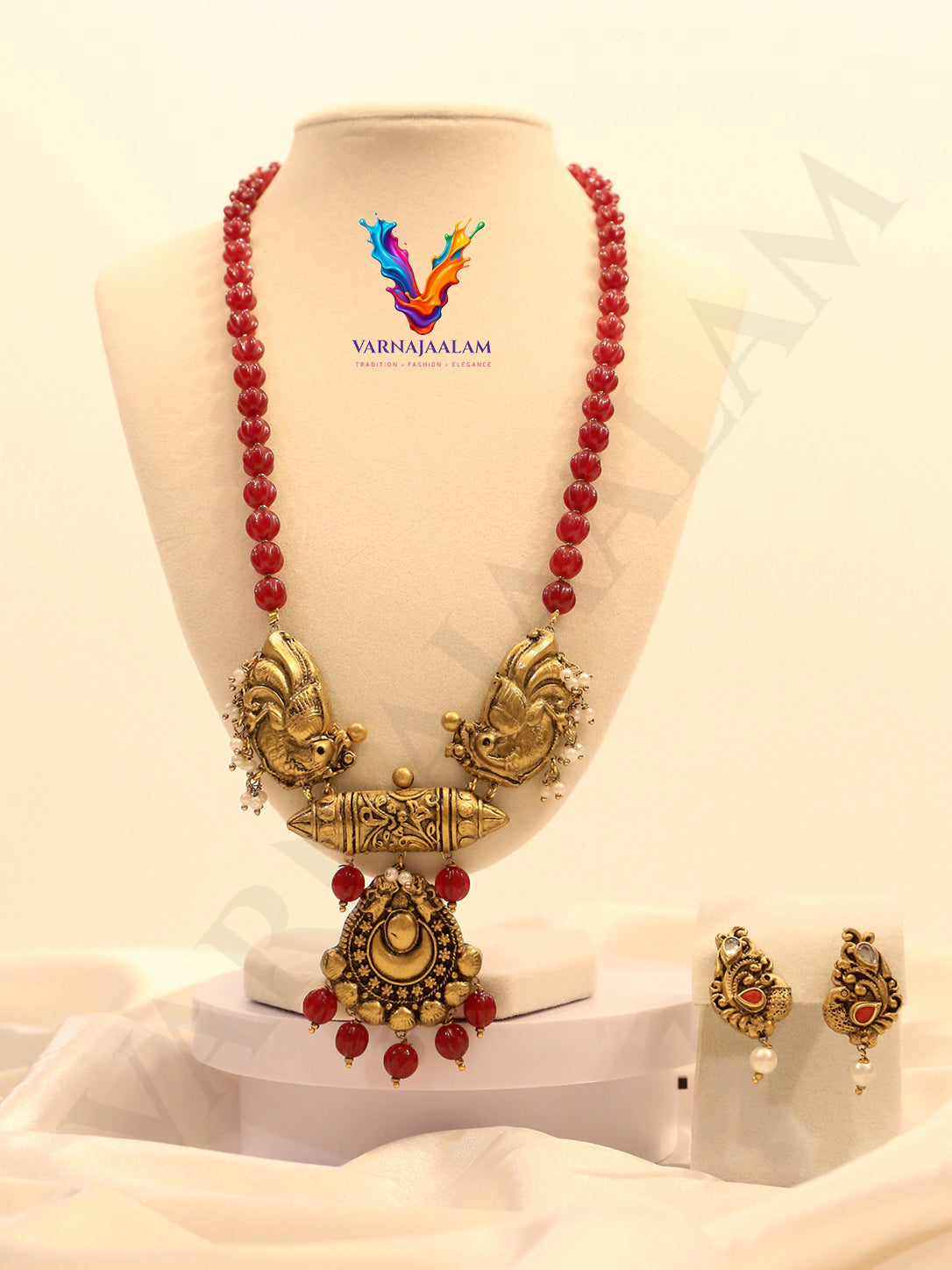 Terracotta red bead mala with gold peacock side motifs, center pendant, and matching earrings