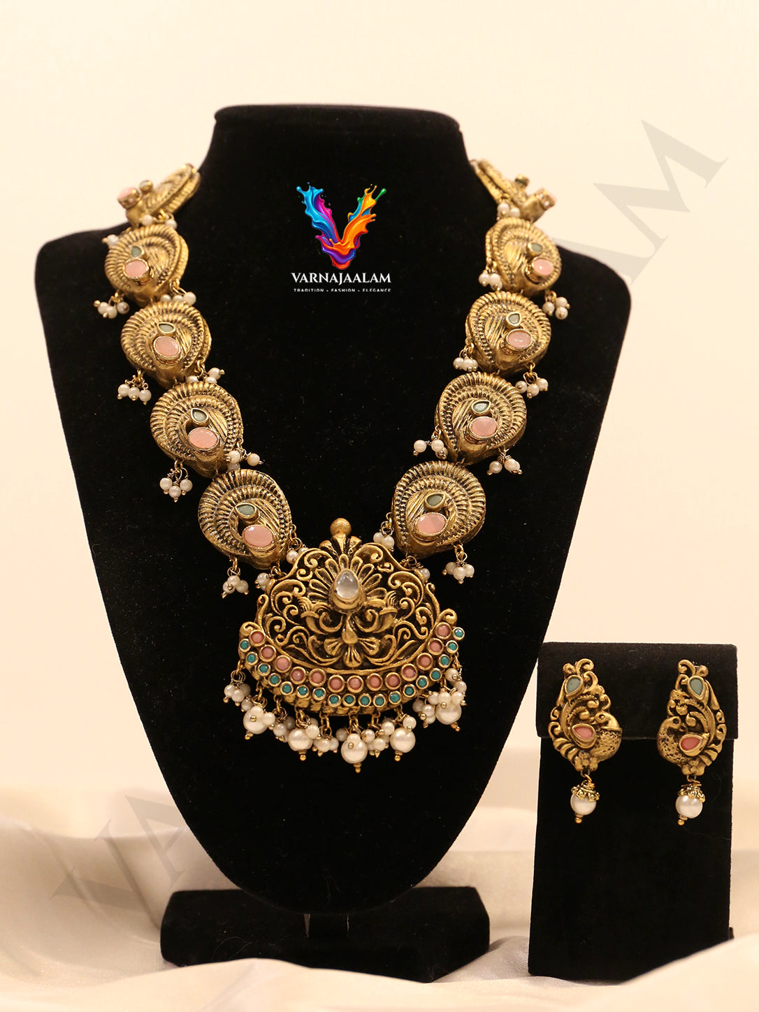 Terracotta gold-toned long haram with pastel stone peacock side motifs, ornate pendant, pearl cluster drops, and matching earrings