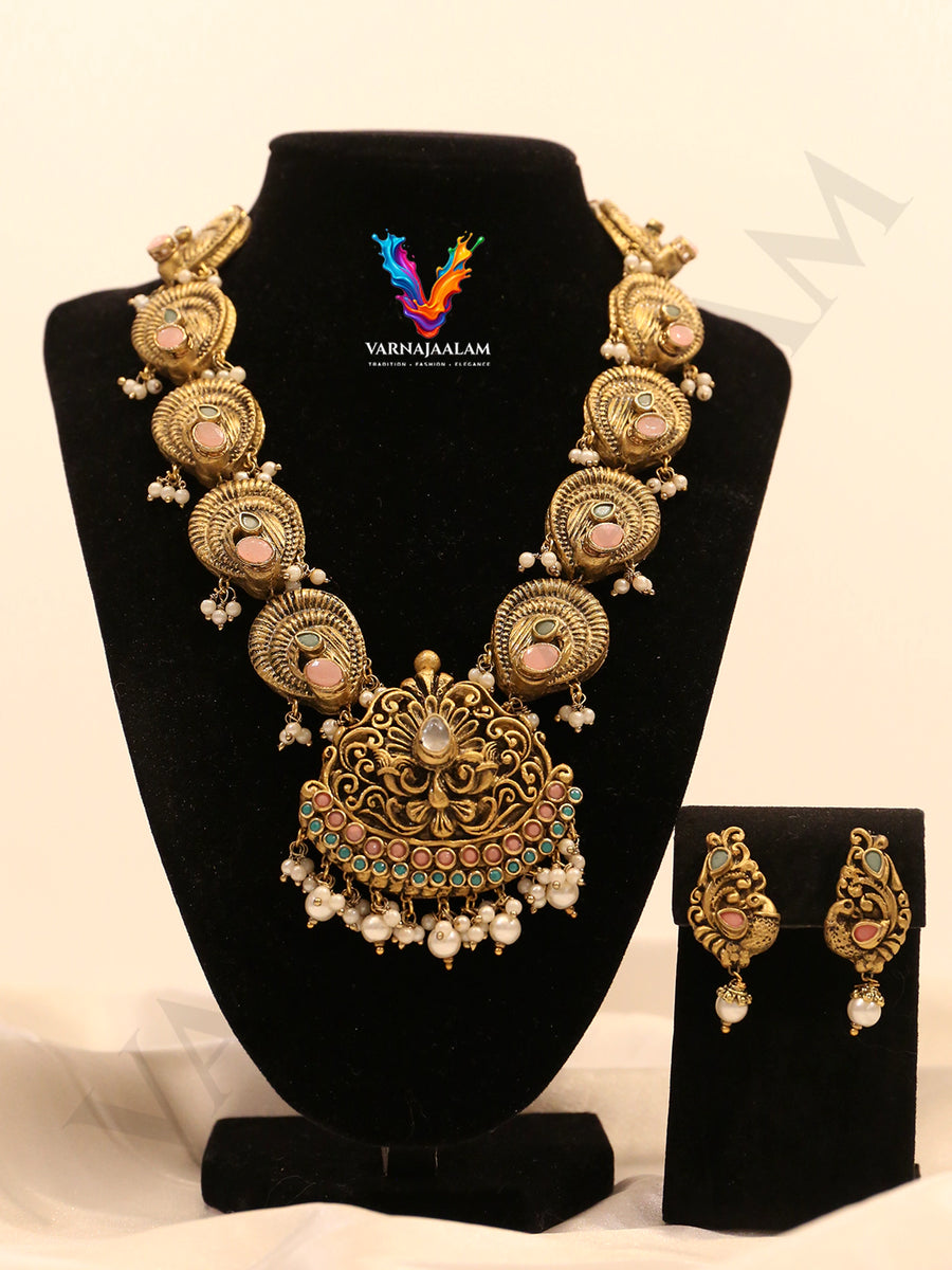Terracotta gold-toned long haram with pastel stone peacock side motifs, ornate pendant, pearl cluster drops, and matching earrings