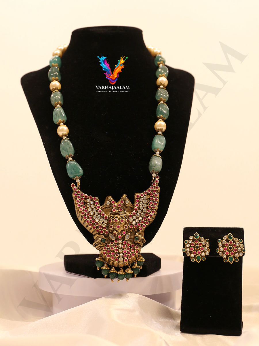 Terracotta long mala with green tumble stones and pearls, featuring a ruby-studded Gandaberunda pendant and matching flower studs