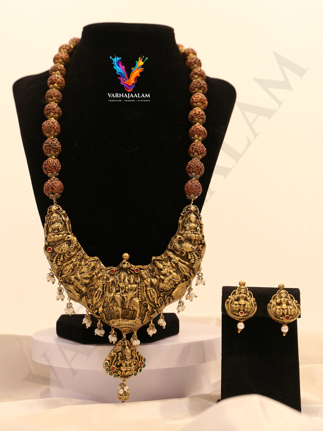 Terracotta long haram with rudraksha beads, large antique gold crescent temple pendant featuring deity motifs with pearl drops, and matching earrings