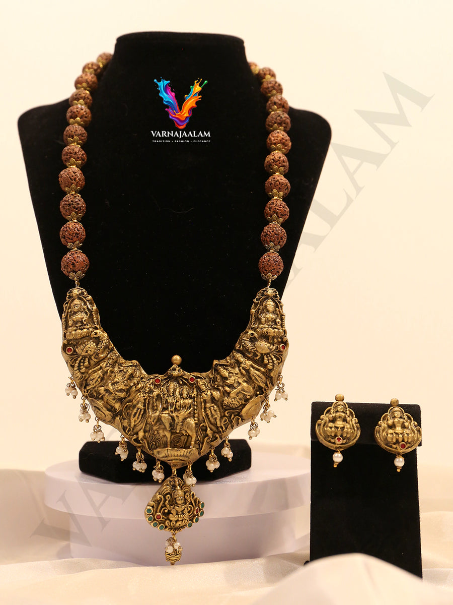 Terracotta long haram with rudraksha beads, large antique gold crescent temple pendant featuring deity motifs with pearl drops, and matching earrings