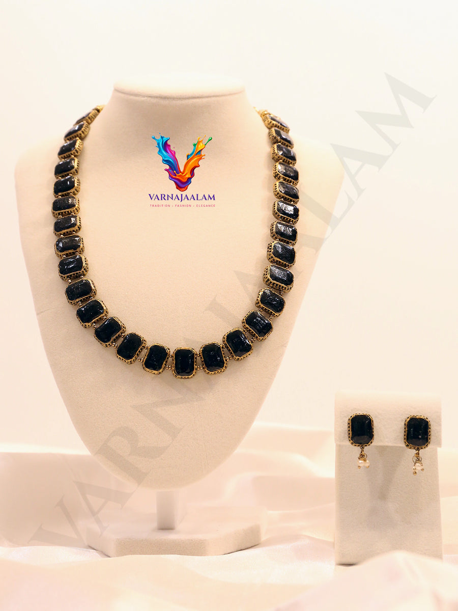 Terracotta gold-framed black rectangular glass necklace with pearl-accented matching stud earrings
