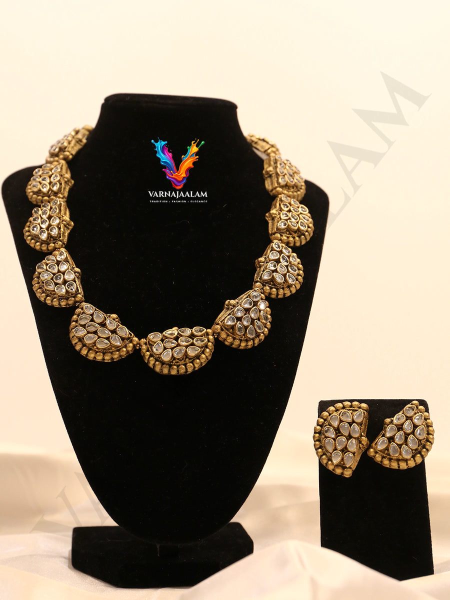 Terracotta antique gold choker featuring crescent-shaped motifs embellished with Kundan stone clusters and matching half-moon stud earrings