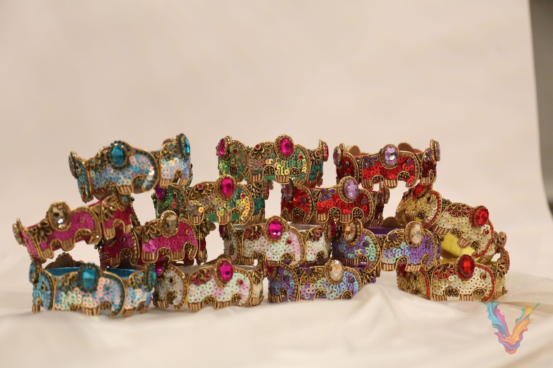 A row of colorful sequin and stone embellished bangles on white satin